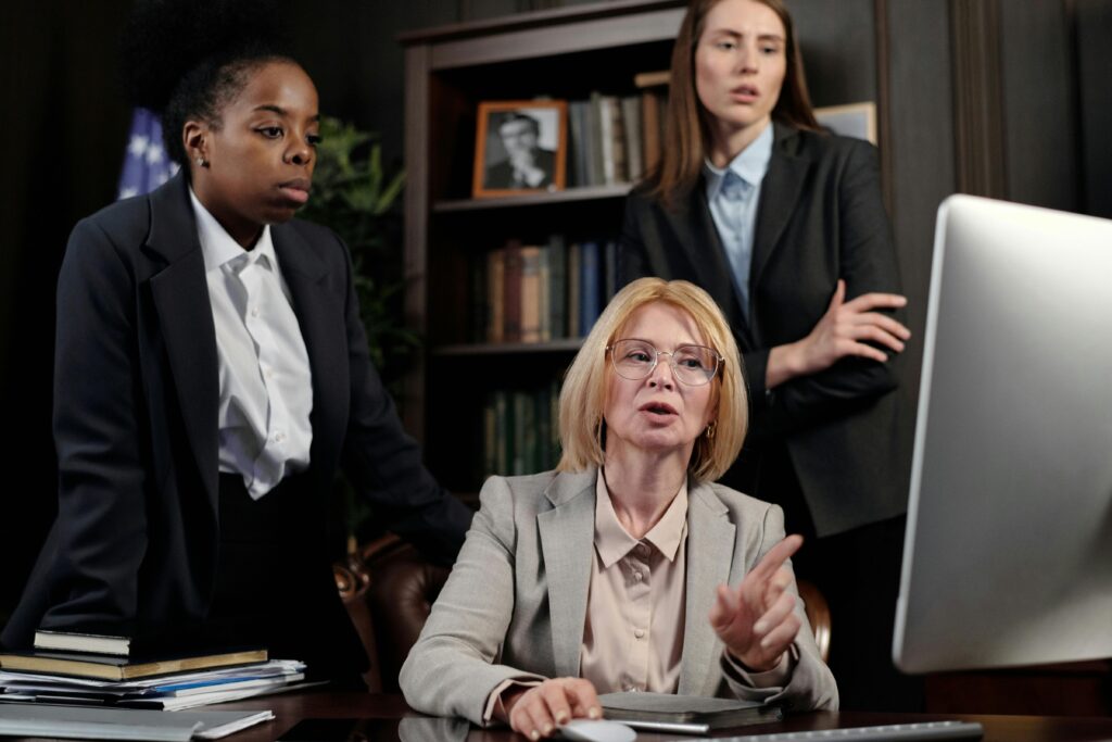 A group of diverse businesswomen collaborating in a modern office setting, discussing work strategies.