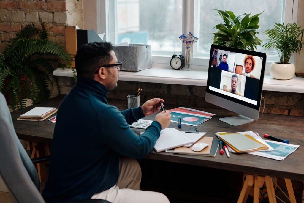 Man engaging in an online meeting from home office, showcasing remote work dynamics.